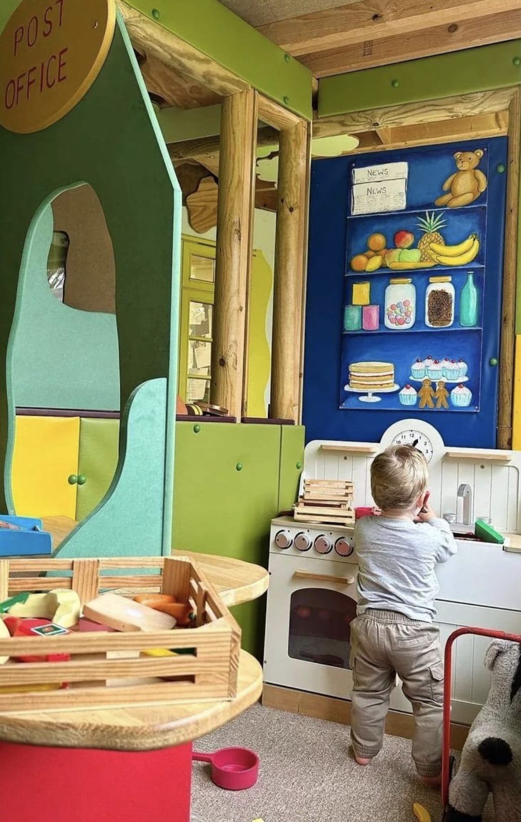 A child playing at the indoor role play kitchen and shop counter